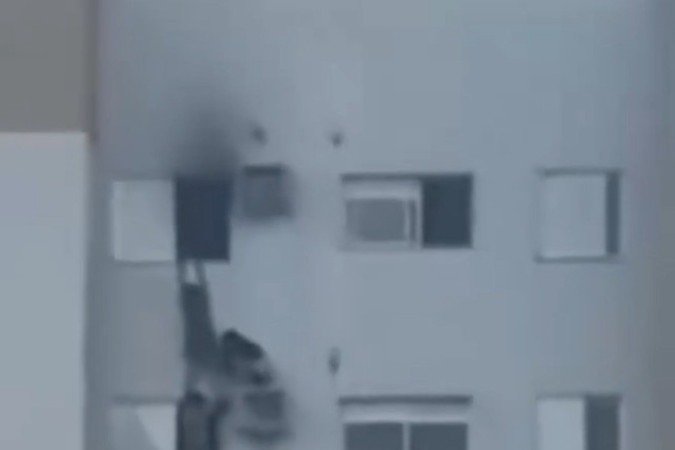 Mulher salva familiares de incêndio pendurada em prédio